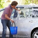 man washing car