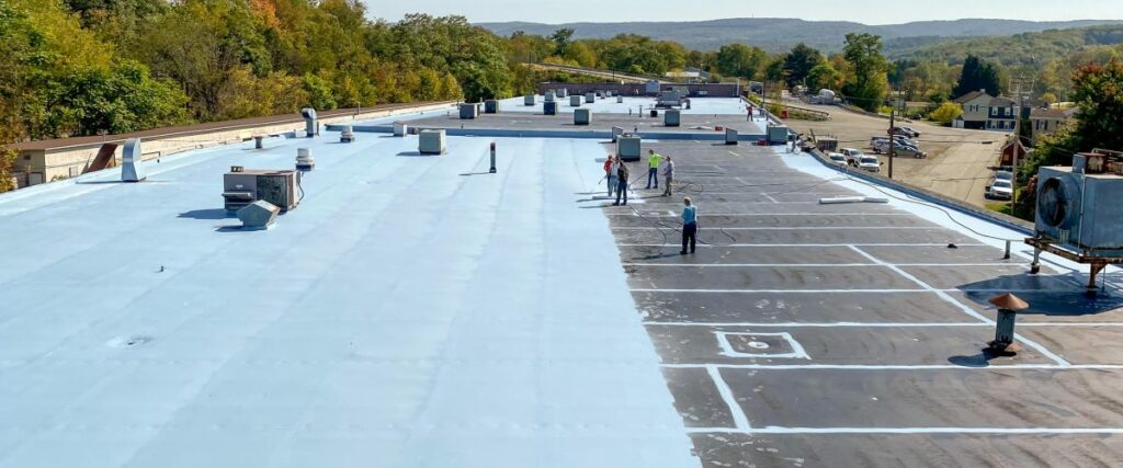 workers applying the conklin roofing system to a large industrial building roof