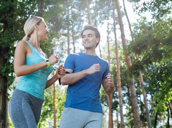couple jogging in wooded area